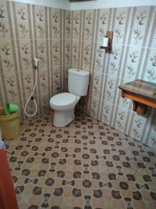 a bathroom with a toilet and a tiled floor at Ocean holiday in Bira