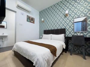 um quarto com uma cama e uma parede com um espelho em Inn Residence 18 em George Town