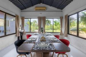 a dining room with a long table and chairs at StayVista's Areca Villa - Mountain-View Haven with Private Pool & Indoor Fun in Nashik
