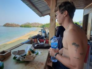a man sitting at a table with a bottle of water at Boneputeh Homestay in Taliwang