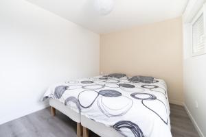 - une chambre avec un lit et une couette noire et blanche dans l'établissement T2 idéal déplacement pro, entièrement rénové, à Rouen