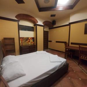 a large bed in a room with a table at Hotel Jan & in the very center in Yerevan