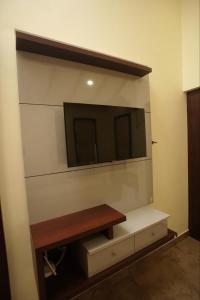 ein Wohnzimmer mit einem TV an der Wand in der Unterkunft Pabis luxurious stay in Vythiri
