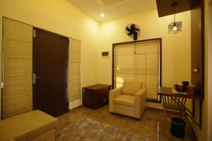 a room with a chair and a mirror and a door at Pabis luxurious stay in Vythiri