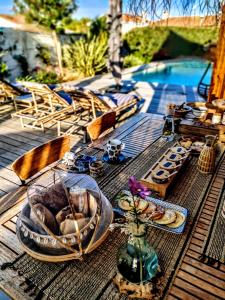 - une table avec de la nourriture à côté de la piscine dans l'établissement La Cabane Bohème, Maison d'hôtes Bassin d'Arcachon, à Gujan-Mestras