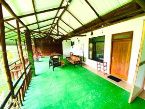 a house with a green floor and a large room at Nice View guest house & restaurant in Ella