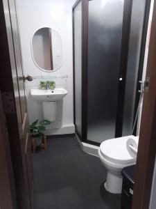 uma casa de banho com um lavatório, um WC e um espelho. em Aloha Hale One Oasis Cdo em Cagayan de Oro