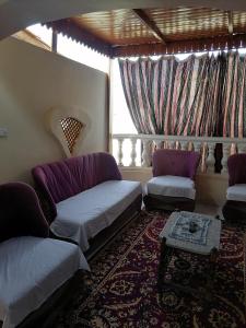 uma sala de estar com um sofá e uma mesa em Djorf apartments em Al Aqālitah