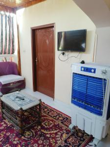 uma sala de estar com um sofá e uma televisão na parede em Djorf apartments em Al Aqālitah