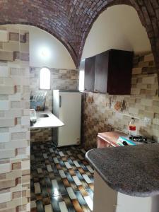 a kitchen with a brick wall and a refrigerator at Djorf apartments in Al Aqālitah +35 photos