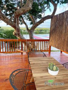 a wooden table with a bowl of fruit on a porch at Palmeras Beach Apartments - Playa Santa in Guanica