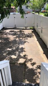 un trottoir avec une clôture blanche dans une cour dans l'établissement cozzy room with private entrance and drive way, à Arlington