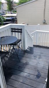 a table and a chair on a wooden deck at cozzy room with private entrance and drive way in Arlington