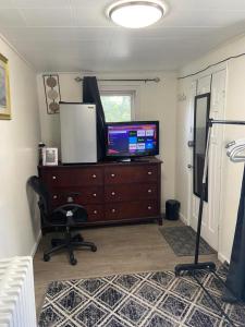 a room with a television on a dresser with a desk at cozzy room with private entrance and drive way in Arlington