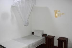 a bedroom with two twin beds and a sign on the wall at Marien Inn in Galle