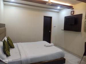 a bedroom with a bed and a flat screen tv at Hotel BKC Palace Inn - Jio world convention center and us visa center హోటల్ బి కే సి ప్యాలెస్ ఇన్ in Mumbai