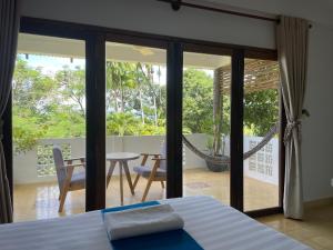a bedroom with a bed and a view of a patio at Kep Lodge in Kep