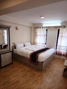 a bedroom with a large bed and a mirror at Hotel Durbar Side in Bhaktapur