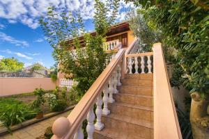 una escalera que conduce a una casa con plantas en Apartments Nadica - free parking, en Nin