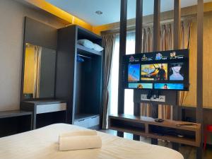 a bedroom with a bed and a flat screen tv at Aeropod Cactus Rail Suite With Balcony - Kota Kinabalu in Kota Kinabalu