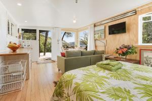 a bedroom with a bed and a couch at The Treehouse - Raglan Holiday Studio in Raglan