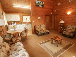 Acorn Lodge في Mydrim: غرفة معيشة مع طاولة ومطبخ
