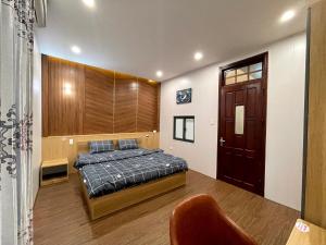 1 dormitorio con 1 cama y puerta de madera en Homestay T&T - Căn hộ gia đình, en Da Nang