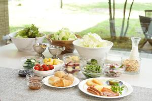 une table avec des assiettes de nourriture et des bols de légumes dans l'établissement 北軽井沢　Golden Forest Hotel, à Naganohara