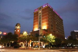 wysoki budynek z wieżą zegarową w nocy w obiekcie Grand Victoria Hotel w Tajpej