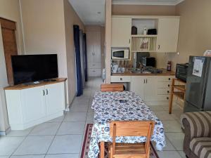 a kitchen with a table with chairs and a television at Desert Pearl Self catering & Accommodation in Walvis Bay