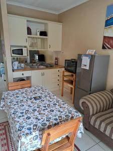 a small kitchen with a table and a refrigerator at Desert Pearl Self catering & Accommodation in Walvis Bay