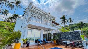 a house with a balcony with a view of the ocean at Caliraya Heights Resorts and Events Place in Halang