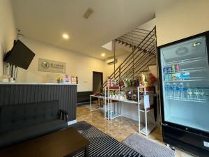 a living room with a refrigerator and a staircase at IJ Lodge in Miri