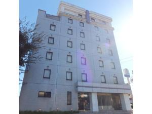 un edificio alto con una luz morada. en Suzuka Royal Hotel - Vacation STAY 38957v, en Suzuka