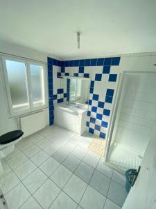 a blue and white bathroom with a sink and a toilet at L'auberge Angevine in Angers