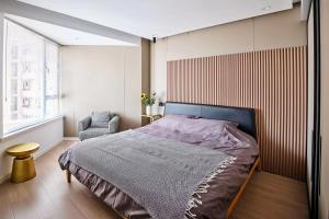 um quarto com uma cama grande e uma cadeira em Datong Elite Apartment, Peoples Square, CBD em Xangai