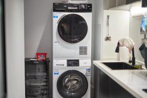 uma máquina de lavar roupa e uma máquina de lavar roupa na cozinha em Datong Elite Apartment, Peoples Square, CBD em Xangai