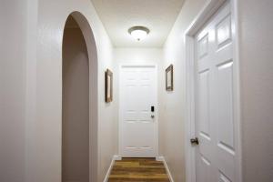 a hallway with a white door and an archway at Spenard Guest House - The Bamboo Room in Anchorage