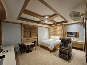 テジョンにあるHotel G7 Daejeonのベッドルーム1室(ベッド1台、デスク、テーブル付)