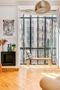 een woonkamer met een bank en een groot raam bij Luxury apartment around Serrano and Juan Bravo in Madrid