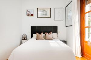 een slaapkamer met een wit bed met een zwart hoofdeinde bij Luxury apartment around Serrano and Juan Bravo in Madrid