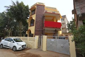 a white car parked in front of a house at Goroomgo Pink Villa Guest House Bhubaneswar in Bhubaneshwar