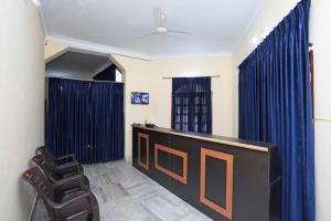 a waiting room with blue curtains and a desk at Goroomgo Pink Villa Guest House Bhubaneswar in Bhubaneshwar