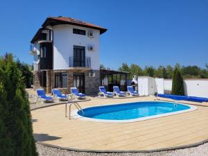 a villa with a swimming pool in front of a house at Golf House Paradise in Topola