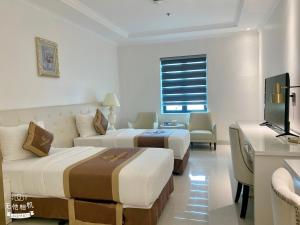 Golden Palace Hotel في هاي فونج: غرفه فندقيه سريرين وتلفزيون