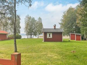 a small red house in a grassy field at Holiday home GRIMSTORP in Grimstorp