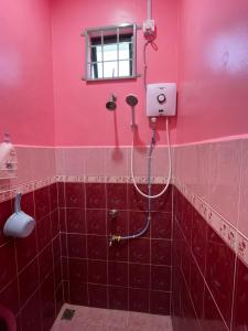 uma casa de banho rosa com um chuveiro na parede em AR HOMESTAY KUALA TERENGGANU em Kuala Terengganu