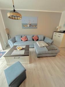 ein Wohnzimmer mit einem blauen Sofa und einem Tisch in der Unterkunft Ferienwohnung Watt un Leev in direkter Strand & Citynähe von Büsum in Büsum