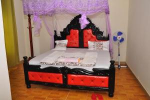 a bedroom with a bed with a canopy at Namulanda Motel in Entebbe