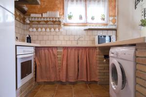 a small kitchen with a washer and dryer at Casa La Tora in Deltebre